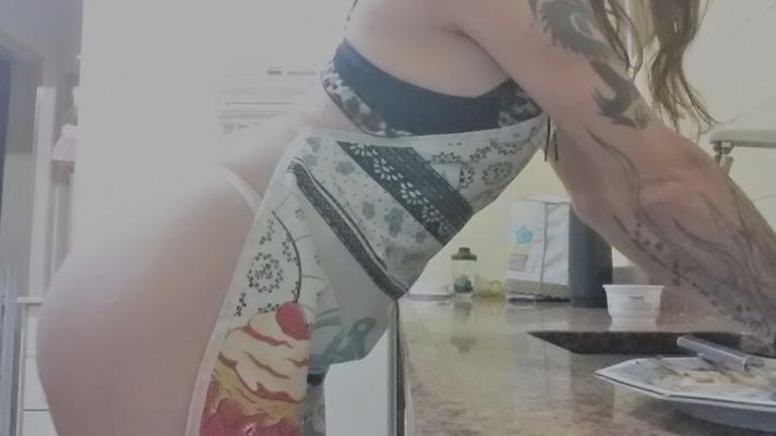 Dona de casa na cozinha só de lingerie e avental