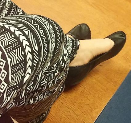 Die sexy Füße der Frau in ihren schwarzen Ballerinas für Kommentare