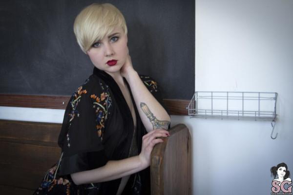 Garota pálida e tatuada de cabelos curtos