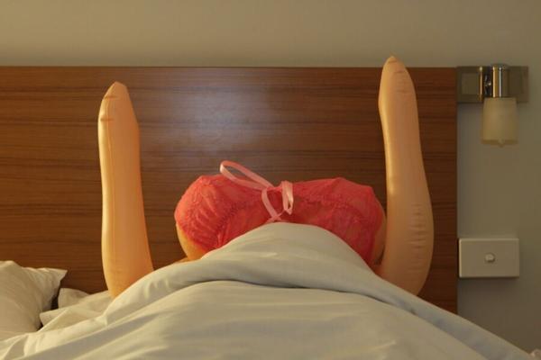 Aller au lit dans un motel avec une poupée d'amour à gros seins.