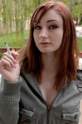 Une rousse qui fume montre ses seins