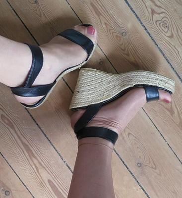 Füße, Nylons und rote Nägel in Wedges