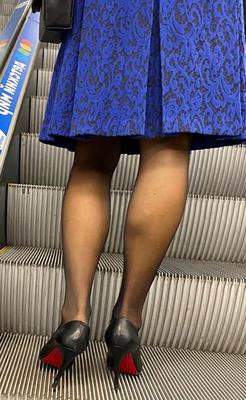 黒のタイツと赤い靴底の革のかかとを履いた女性