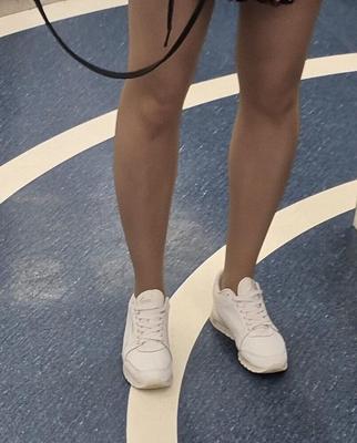 Girl in tan pantyhose, dress and sneakers