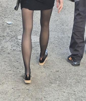 Skinny girl in pantyhose and midi skirt