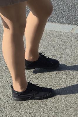 日焼けした光沢のあるパンストとミニスカートの女の子