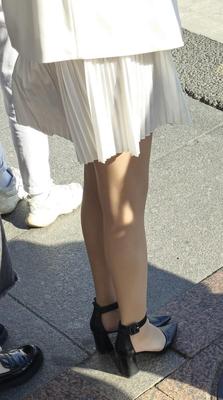 Fille en robe blanche, collants brillants et talons en cuir