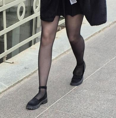 Girl in mini skirt, black pantyhose and suede sandals