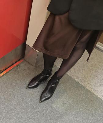 Fille en cols noirs, jupe brune et bottines en cuir