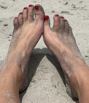 Kristin mostrando su bola drenando los dedos de los pies en la arena