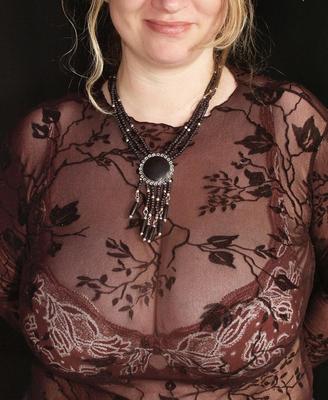 彼女の大きなおっぱいの裂け目を提示する巨乳の熟女の女